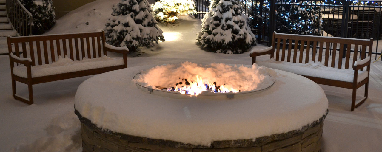 Foyer extérieur allumé et entouré de neige